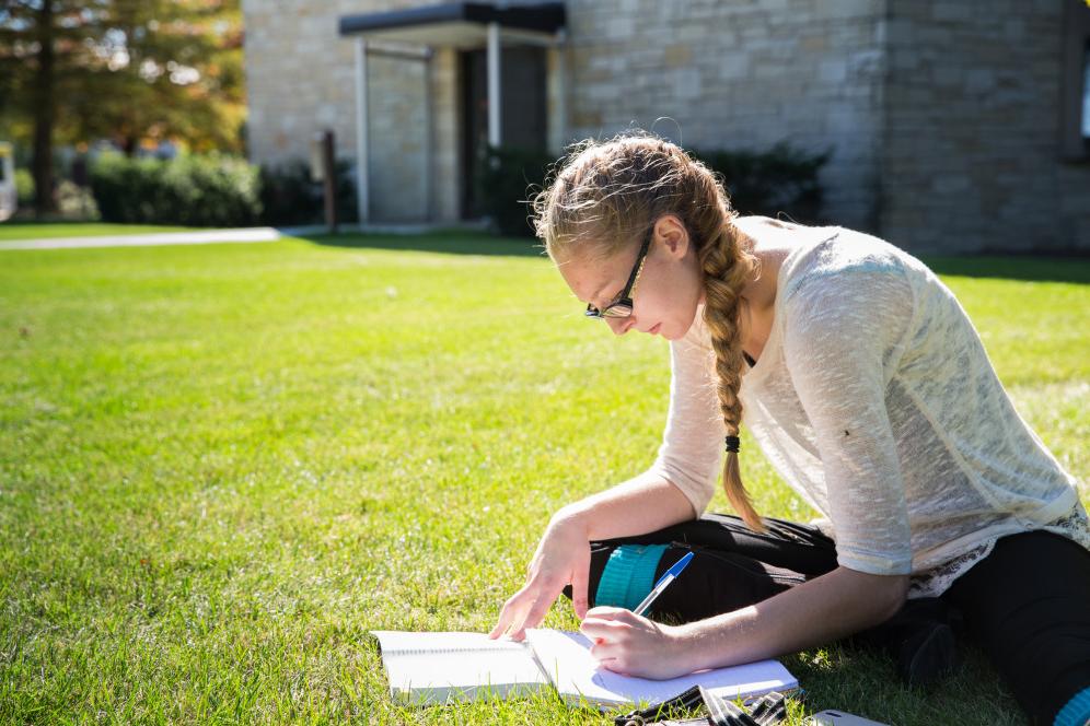 A student studies outside. 办公室写手是众多学生就业机会之一...